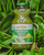 A bottle of Super Greens amongst lush green foliage