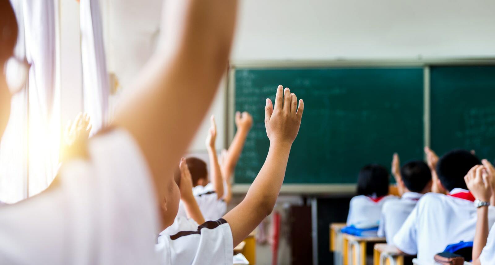 Students rising their hand in class