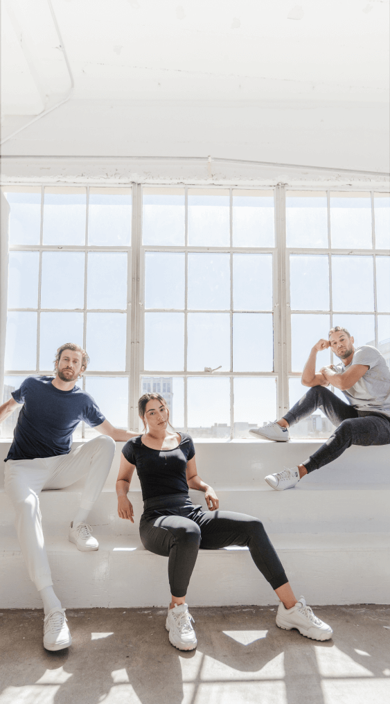 Two men and one woman wearing Thompson Tee undershirts