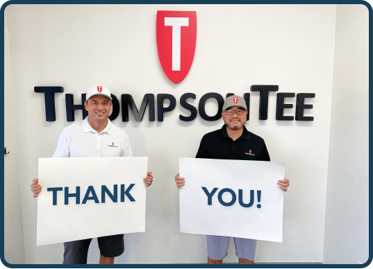 Thompson Tee co-founders holding a Thank You sign