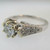 18k White Gold Approx 1.07ct TW Round Brilliant Cut Diamond with Accent Diamonds Surrounding Mount. Size 6 ¼
