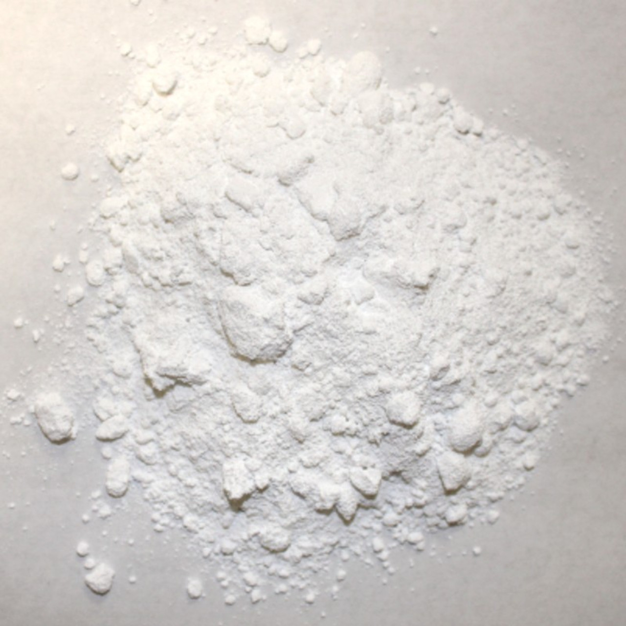 Titanium dioxide powder in black bowl. TiO2 also known as titanium (IV)  oxide or Titania. Food additive, E171. Inorganic compound, white chemical  alimentary pigment Photos