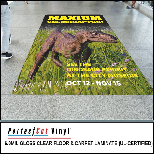 PerfectCut Vinyl 6.0mil gloss clear floor and carpet laminate, UL-certified, shown protecting a dinosaur museum exhibit floor graphic reading "Maximum Velociraptor!" in a public walkway.