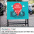 PerfectCut Vinyl 3.4mil matte white opaque block-out print vinyl with permanent adhesive, shown printed as a teal "Bike Rental" A-frame sidewalk sign with a bicycle and city skyline graphic on a cobblestone street.