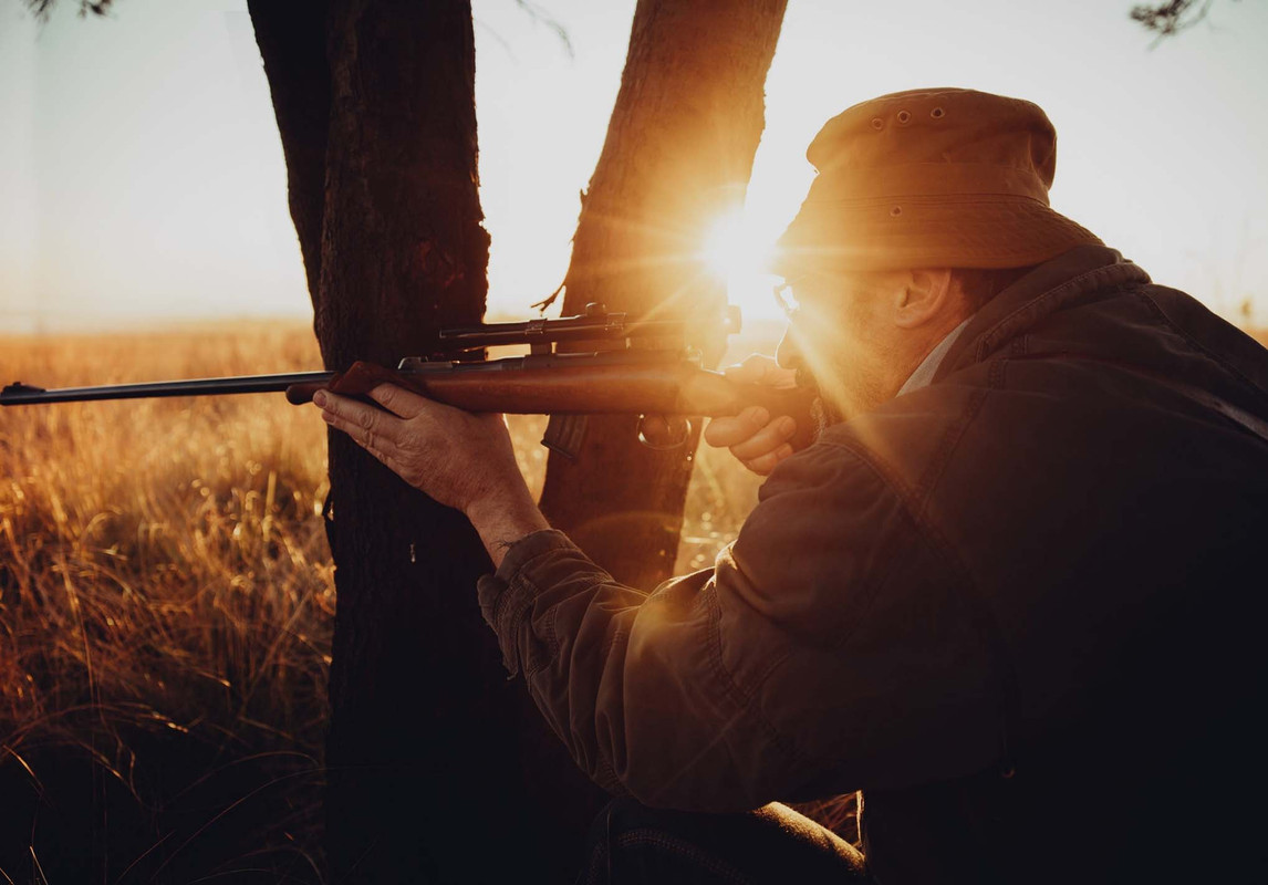 Man looking through scope on rigle