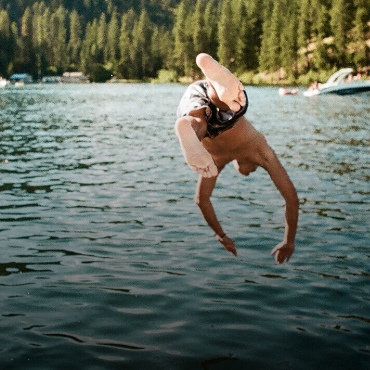 Young man dives headfirst into beautiful, natural lake