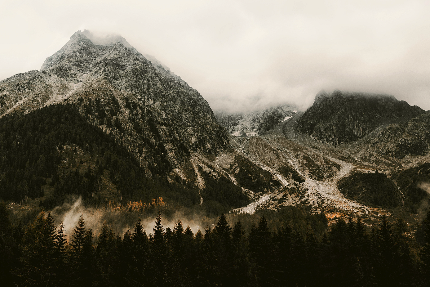 Mist drifting over a forested alpine ridge at first light