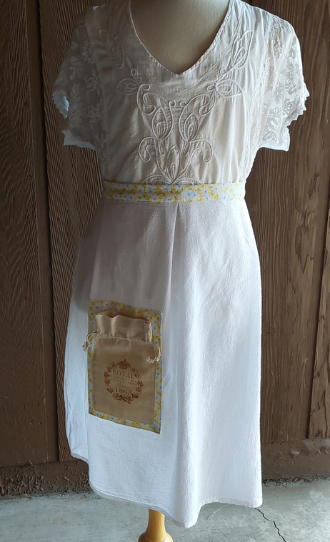 Linen tea towel apron with yellow print waist band and pocket placket.