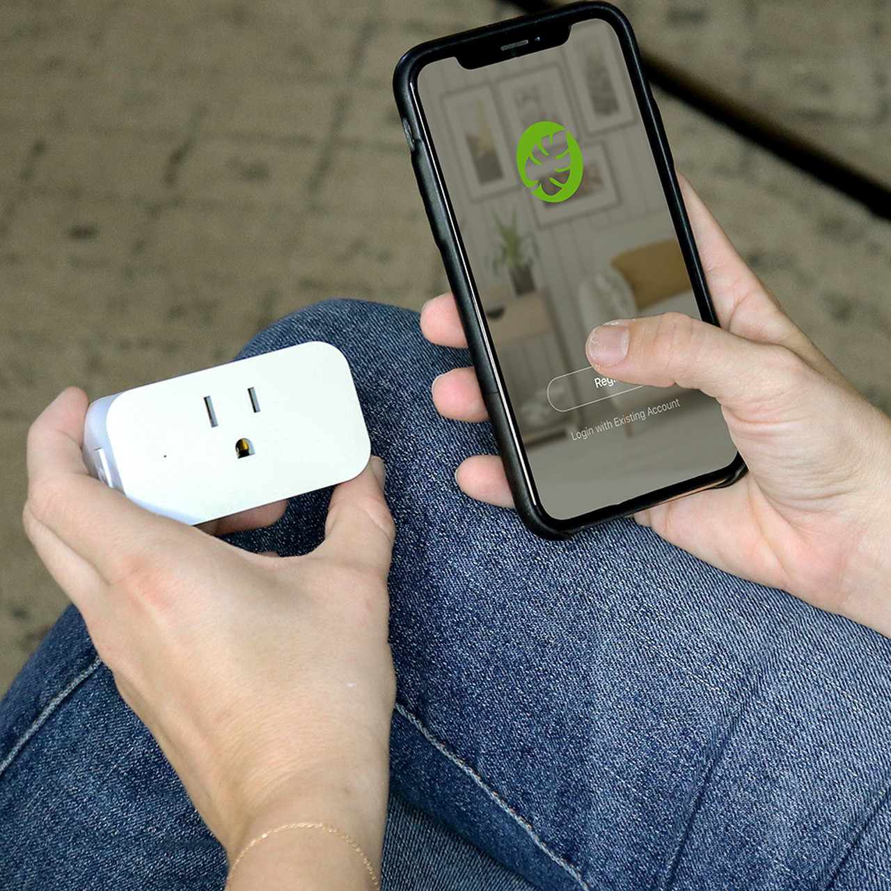 Person using Simply Conserve app on their phone while holding a Smart Socket