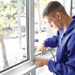 Man lining window ledge with foam tape Man lining window ledge with foam tape