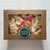 A strand of popcorn garland tied with a red ribbon bow, inside of a brown, bakery-style box visible through a clear cellophane window.