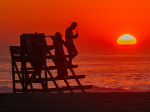 Sunrise Over People On A Lifeguard Stand