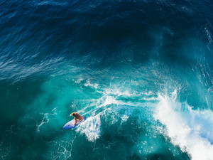 Aerial View of a Surfer Riding a Sapphire Blue Wave