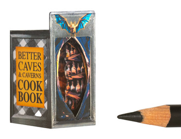 A miniature book nook containing a witch's kitchen and Halloween scene.
