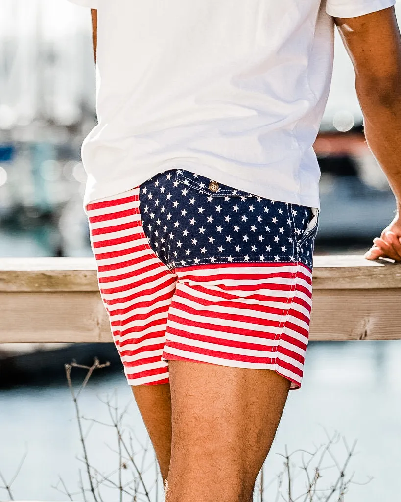 Picture of a back of a man wearing stars and stripes shorts in red, white, and blue colors.