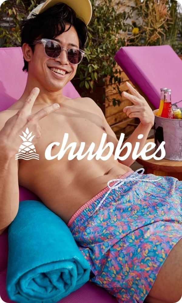 Man relaxing on beach chair with Chubbies swim trunks, logo on top