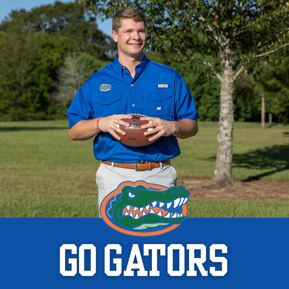 The University of Florida Collegiate Apparel. Man throwing football wearing a blue University of Florida short sleeve button down shirt.