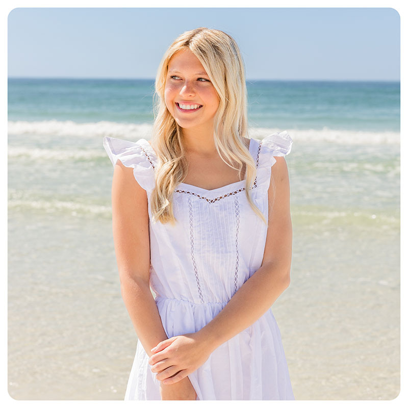 A girl wearing a sundress on the beach