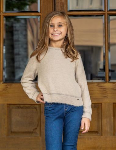 Girl in sweater and jeans smiling