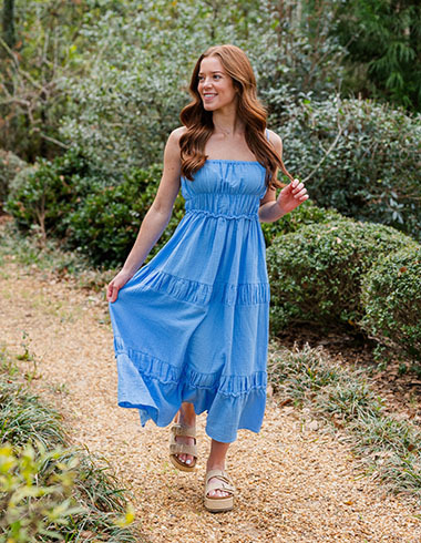 Woman in a blue maxi dress walking on a trail