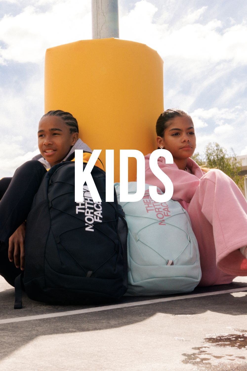 Two kids wearing The North Face apparel with text, "Kids," over it