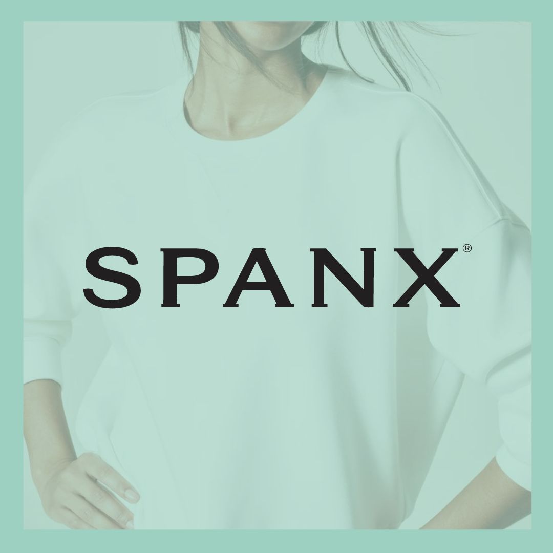 Women's Spanx Brand Apparel. Close-up of a woman wearing a white Spanx pullover shirt.