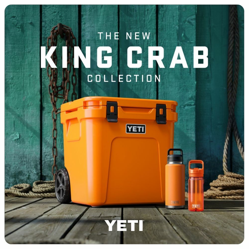 The New King Crab Collection from Yeti, image features a wheeled Yeti Cooler in King Crab Orange on a fishing dock with two drinkware items sitting next to it.