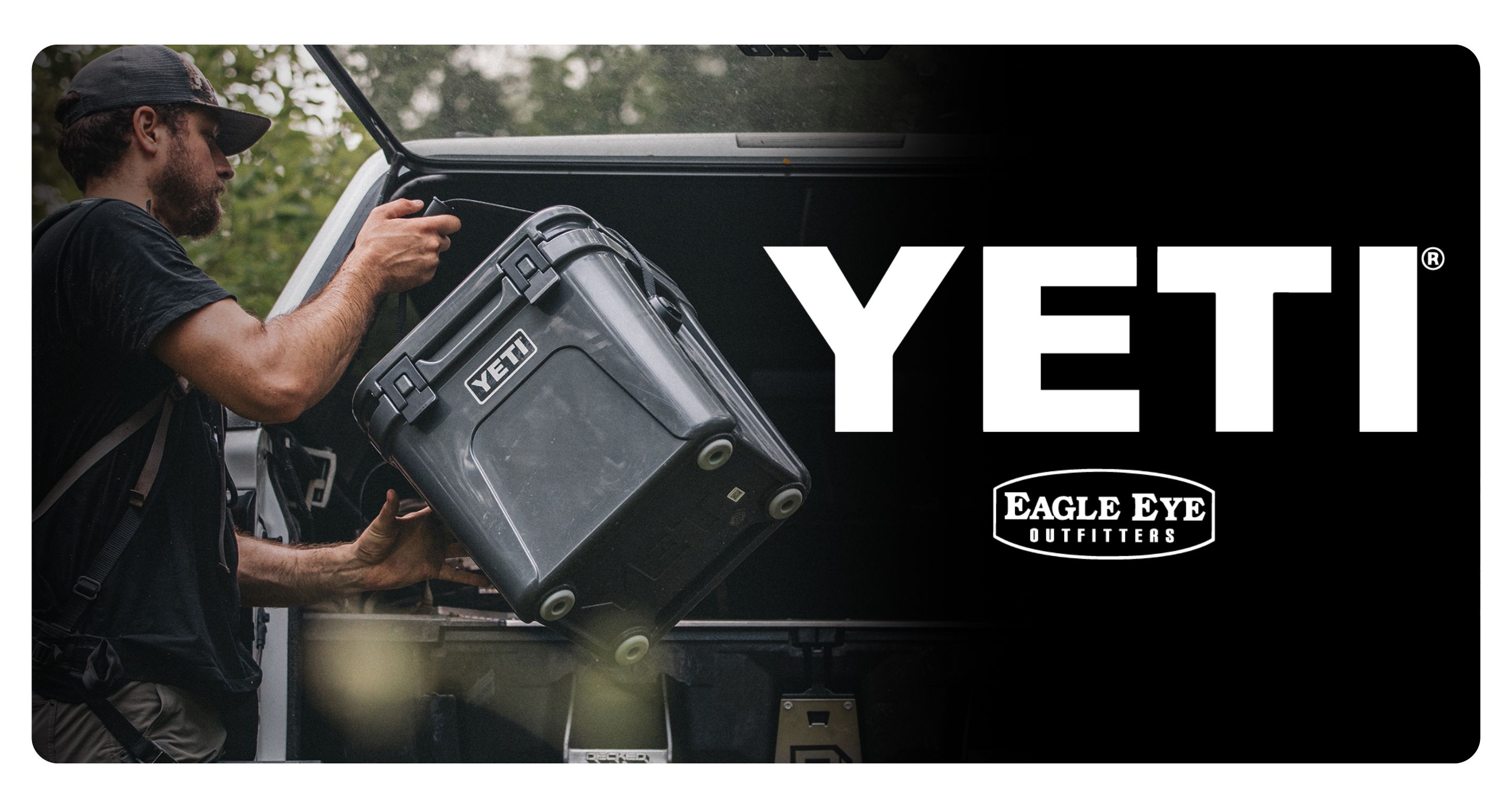 Man putting Charcoal Yeti Roadie cooler in the back of his hatchback with Yeti and Eagle Eye Outfitters logo.