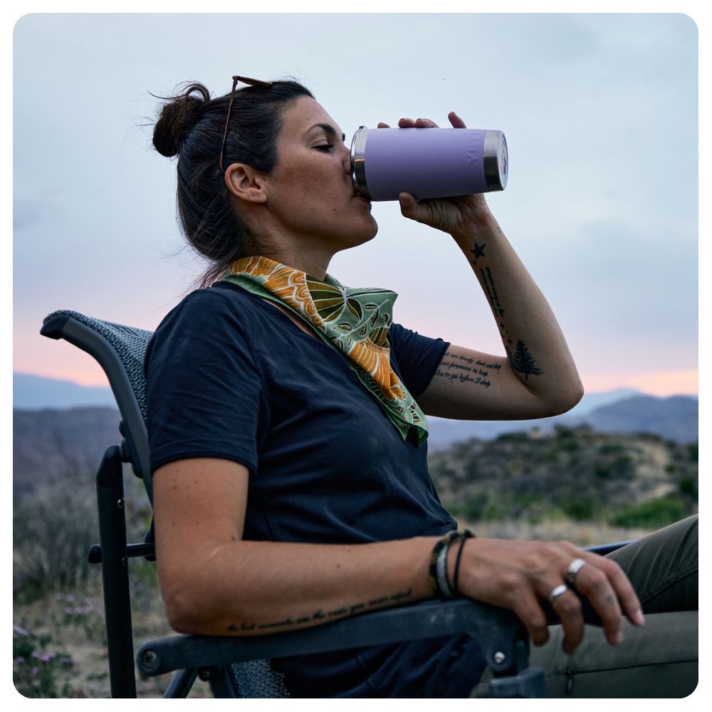 Woman sitting in a chair drinking from a Yeti Power Pink tumbler