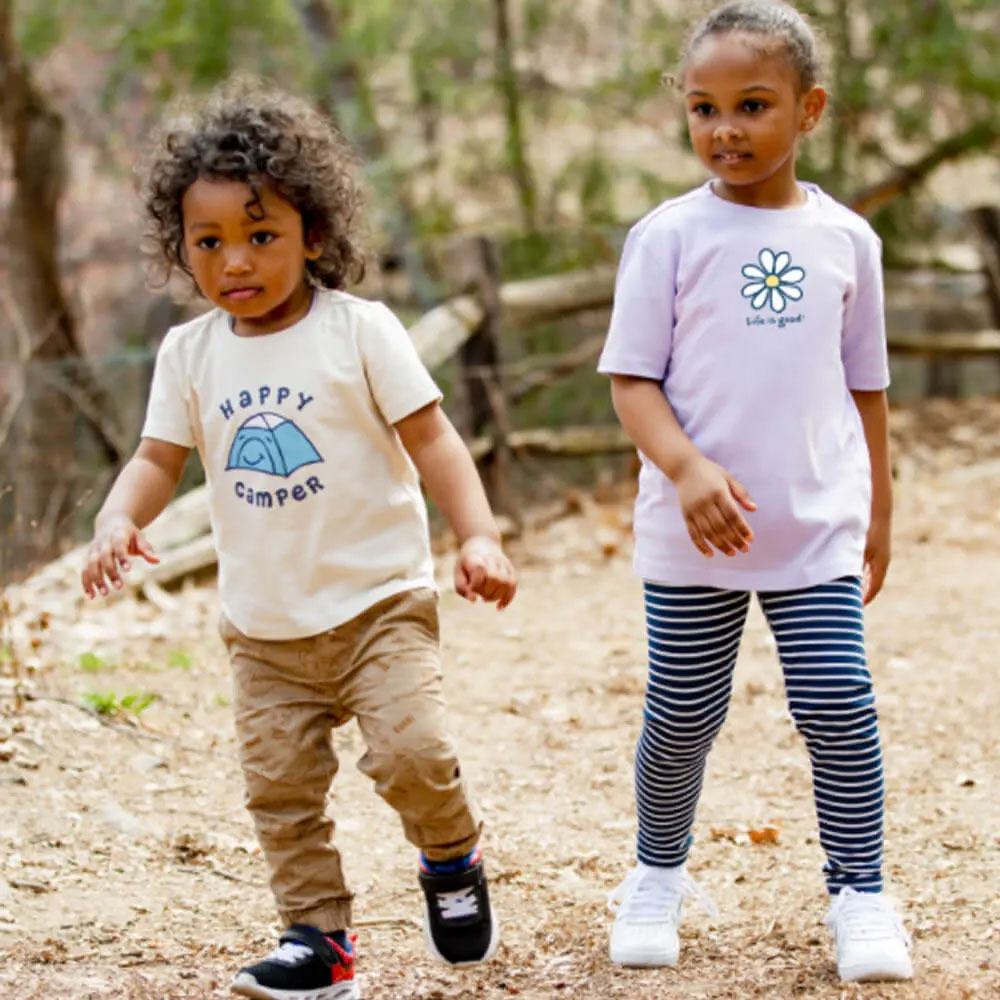 A young boy and girl outside on a hiking trail wearing pants and Life is Good t-shirts.