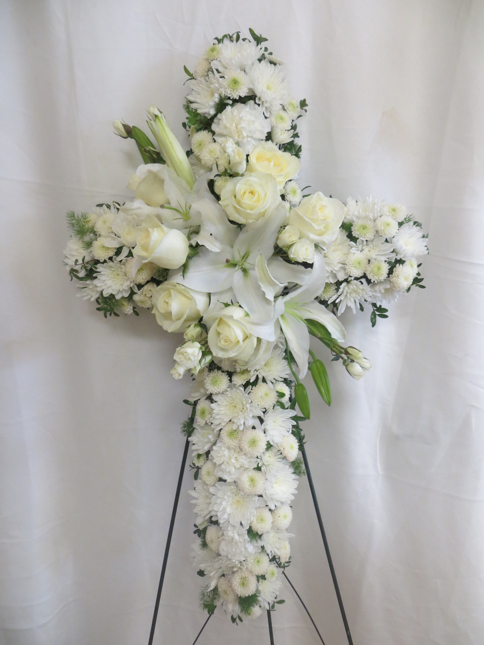 All white wreath for memorial service with lilies and roses