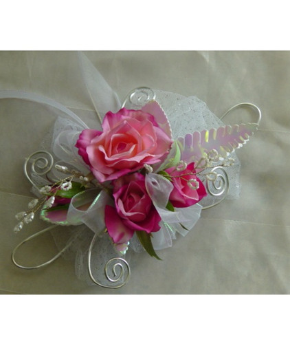 Pink Rose White Iridescent Silver Trimmed Prom Flowers Corsage by Enchanted Florist Pasadena TX. Pink spray roses in a wrist prom corsage with white iridescent and silver trim bling. PROM101