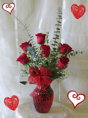 Deluxe Half Dozen Red Roses by Enchanted Florist Pasadena TX.  6 premium red Ecuadorian roses in an upgraded red vase with upgraded tropical foliages. Send red roses in Deer Park TX, Pasadena, Houston, and surrounding areas. RM932