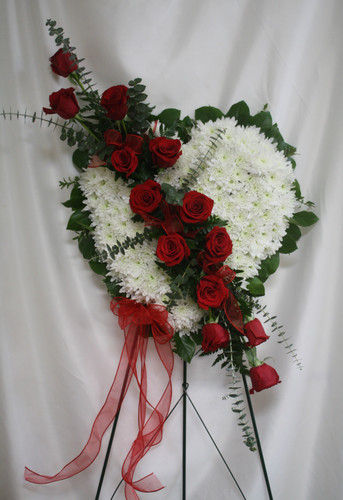 Bleeding Heart Funeral Flowers with Red Roses from Enchanted Florist.  Our standing spray arrangement - in the shape of a heart - is created from fresh white mums and red roses and is accented with eucalyptus.
SKU RM574