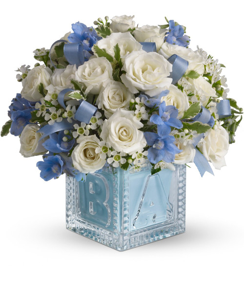 Crystal Block New Baby Boy Flower Bouquet by Enchanted Florist Pasadena TX. Send new baby boy flowers in the adorable keepsake crystal block. Includes miniature white spray roses, the blue flowers are delphinium and ribbons tucked in. Simply stunning, just like a new baby! RM306