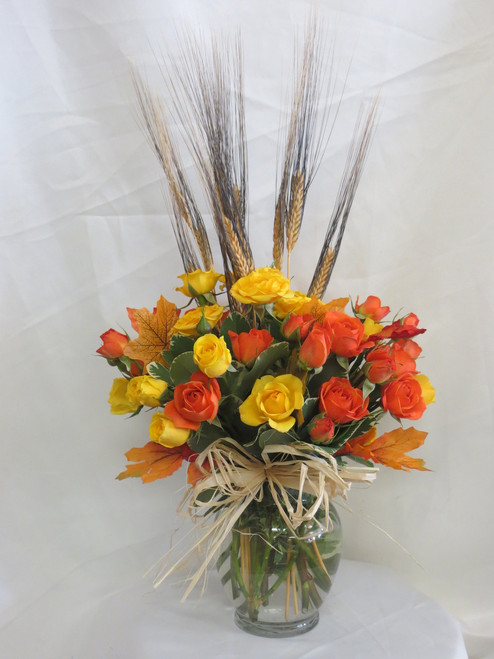 Fall Simply Spray Rose Bouquet by Enchanted Florist Pasadena TX. Our fall bouquet of yellow and orange spray roses in a clear vase with wheat accents and fall leaves perfect for a side table or desk. We offer same day delivery on fall flowers for delivery in Pasadena TX and surrounding areas. RM206