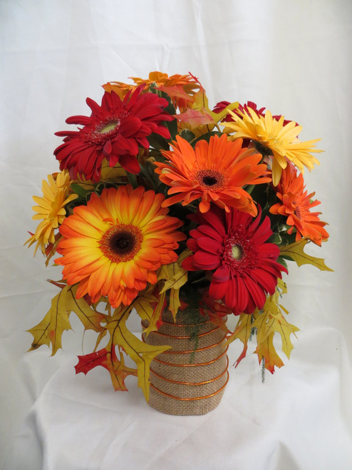 Autumn Magic Gerbera Daisy Bouquet by Enchanted Florist Pasadena TX. This lovely all fall gerbera daisy bouquet includes a mixture of fall colored gerbera daisies of red, yellow, and oranges arranged in a burlap vase accented with orange wire and fall leaves. Approximately 13"H x 10"W.
SKU RM207