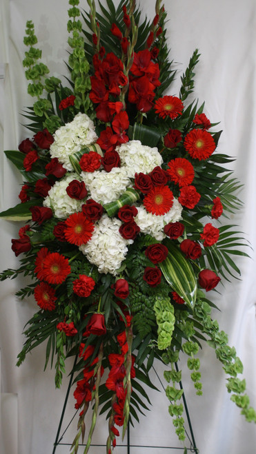 Firelight Large Red Rose and White Hydrangea Standing Spray of Flowers from Enchanted Florist.  One of our largest sprays in reds and white, our custom spray includes red roses, red carnations, red gladiolas, red gerbera daisies, white hydrangeas and bells of Ireland, and lots of green foliage to set the design off. Approximately 70"H x 40"W (size not including stand)
SKU RM554