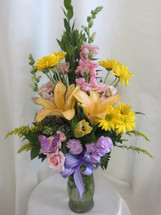 The Lavender Blossom Lily Snapdragon Flower Bouquet by Enchanted Florist Pasadena TX is a smaller version of our In the Moonlight Bouquet. This lovely pastel bouquet includes peach lilies, yellow daisies, pink snapdragons and pink spray roses in a clear glass vase. A beautiful soft colored flower arrangement sure to please. Approximately 24"H x 12"W. 
SKU RM158