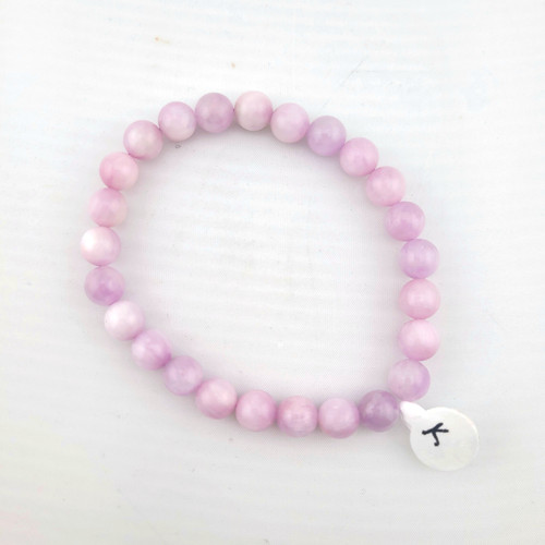Single kunzite 8mm beaded bracelet photographed from above on white background