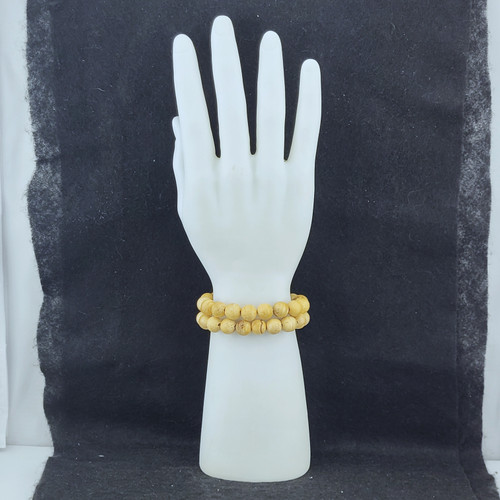 Palo Santo bead bracelet being shown on a white hand mannequin against a black backdrop