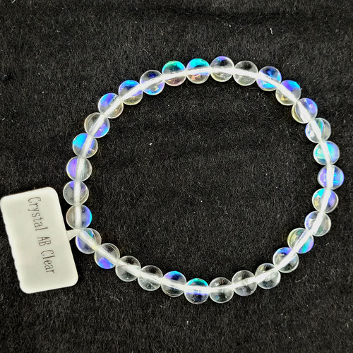 Overhead view of a circular Angel Aura Quartz stretch bracelet on a dark background.
