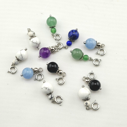 A collection of individual bracelet charms including Amethyst, Green Aventurine, and Lapis Lazuli with silver attachments.