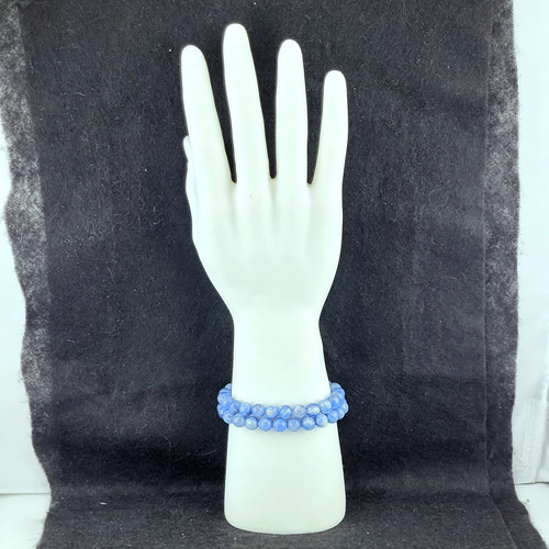 Polished Blue Kyanite bead bracelets stacked on a white mannequin hand display against a dark background.