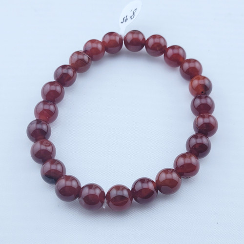A single Red Agate stretch bracelet with 8mm polished beads in deep crimson and burnt orange tones.