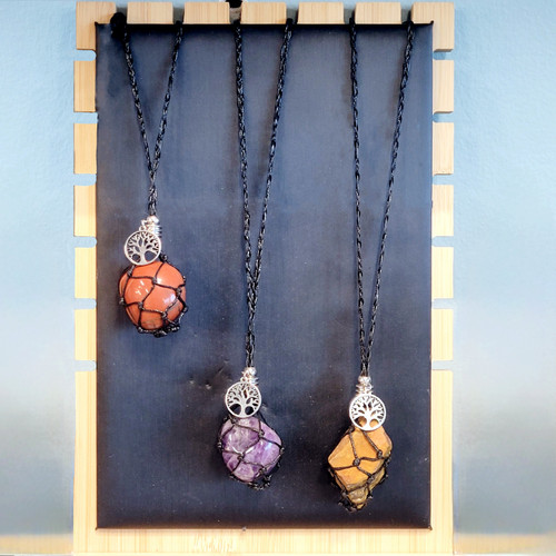 Three black macramé interchangeable crystal holder necklaces featuring different stones and silver Tree of Life charms.