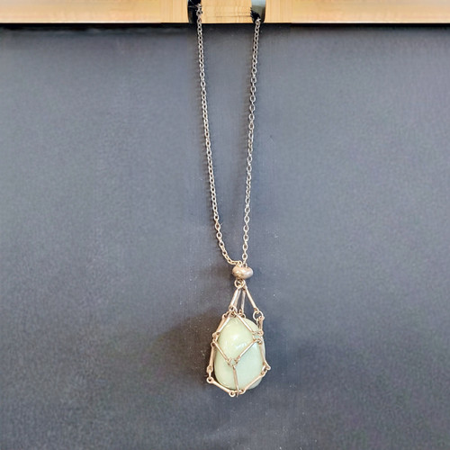 Minimalist silver-toned metal nest pendant designed to hold tumbled stones and crystals.