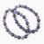 Amethyst and black tourmaline 8mm bead bracelets arranged in a flat lay showing alternating purple and black natural gemstone beads.