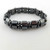 Hematite 2-tiered bracelet arranged in circle on white background with polished finish.