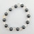 Hematite and clear quartz beaded bracelet laid flat showing alternating gemstone pattern on white background.